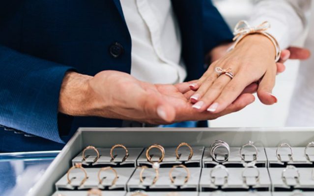 woman trying on engagement ring in jewellery shop