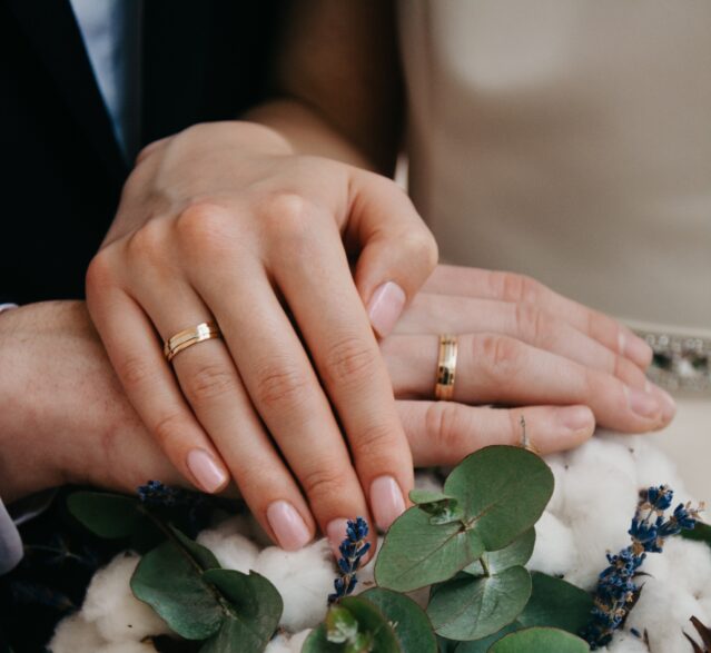 man and woman wearing gold wedding rings