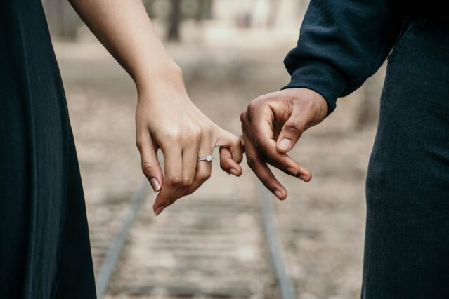 couple holding hands wearing promise ring