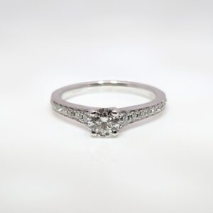 This 18ct white gold diamond engagement ring has an elegant milgrain edge encasing the shoulder stones, and a high-set centre stone making it ideal for your future wedding band.