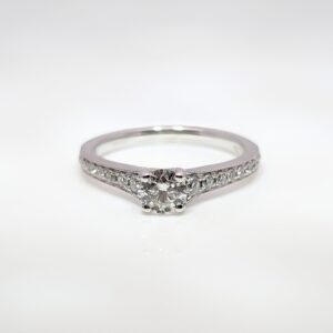 This 18ct white gold diamond engagement ring has an elegant milgrain edge encasing the shoulder stones, and a high-set centre stone making it ideal for your future wedding band.