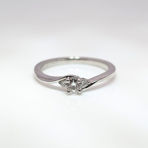 Discover our Trilogy Twist Engagement Ring 0.17ct Centre Diamond in 18ct White Gold . Celebrating the ‘past, present, and future’ symbolism, this piece makes an exceptional engagement ring or something to celebrate a special occasion.