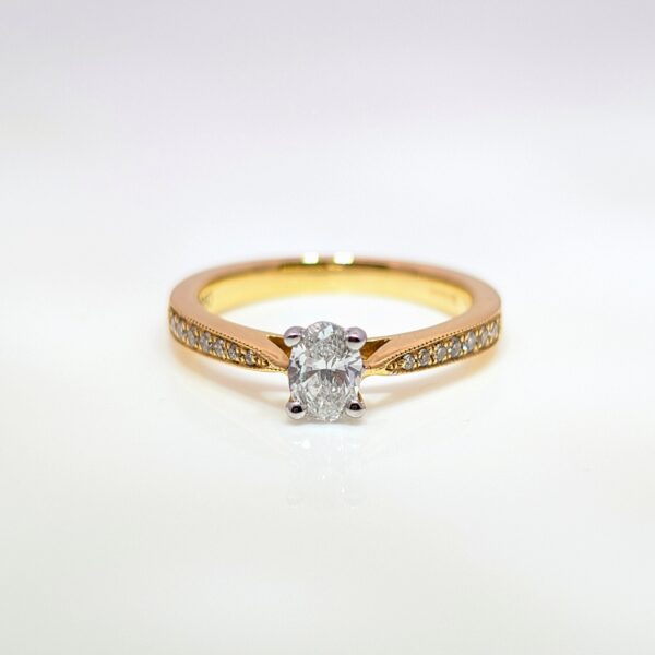 Discover our 4 Claw Oval in 18ct Yellow Gold, with a Centre Stone and Pavé set Diamond Shoulders. Oval Diamond Engagement Ring.
