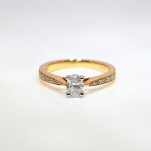 Discover our 4 Claw Oval in 18ct Yellow Gold, with a Centre Stone and Pavé set Diamond Shoulders. Oval Diamond Engagement Ring.